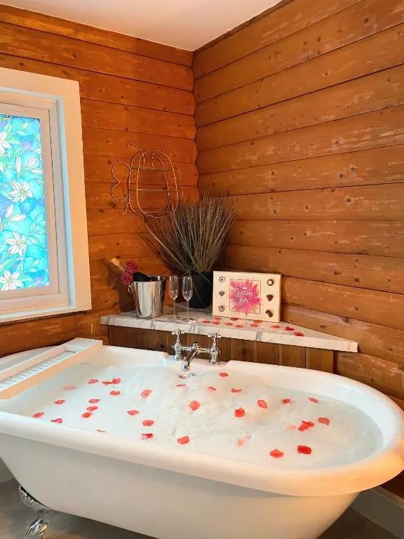 a bath tub in a room with wooden walls at Kaoglen Doe-Feature Bathroom-Cairngorms-Pets Allowed in Balnald