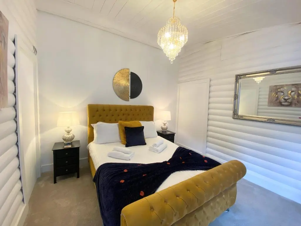 a bedroom with a bed with a yellow tufted headboard at Kaoglen Doe-Feature Bathroom-Cairngorms-Pets Allowed in Balnald