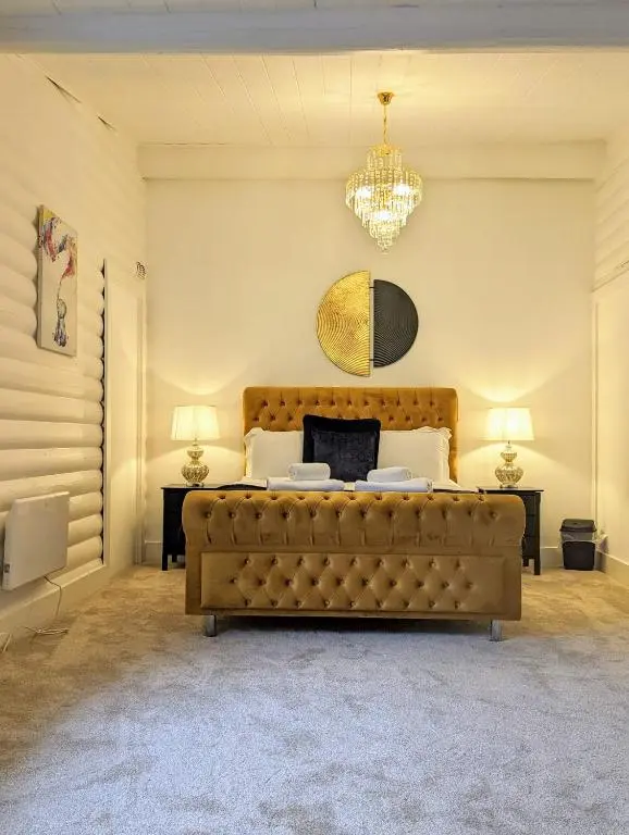 a bedroom with a large bed and a chandelier at Kaoglen Doe-Feature Bathroom-Cairngorms-Pets Allowed in Balnald