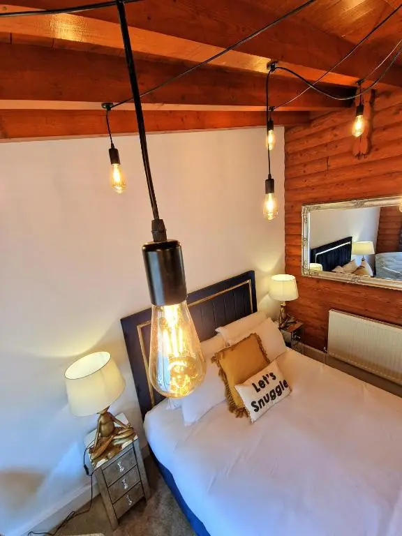 a bedroom with a bed and a large light fixture at Kaoglen Squirrel Drey-Hot Tub-Pet Friendly-Perth in Balnald