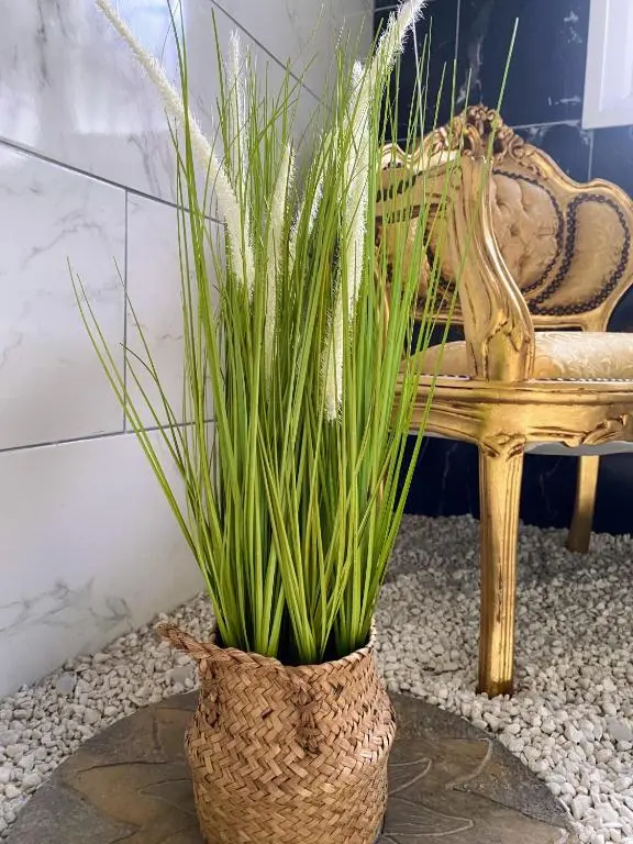 a vase with plants in it next to a chair at Kaoglen Zen-Feature Bath-Dunkeld-Route 500 in Balnald