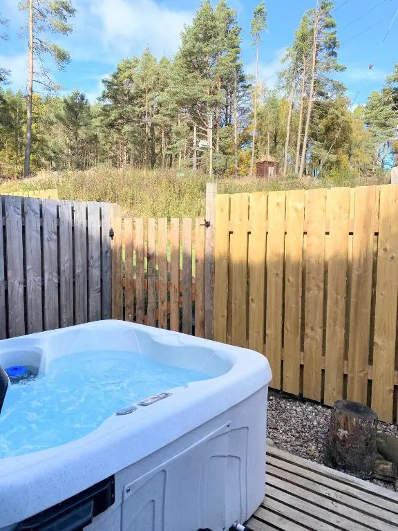 a hot tub in a yard next to a wooden fence at Kaoglen-Spruce-Hot Tub-Forrest Setting-Pet Friendly in Balnald