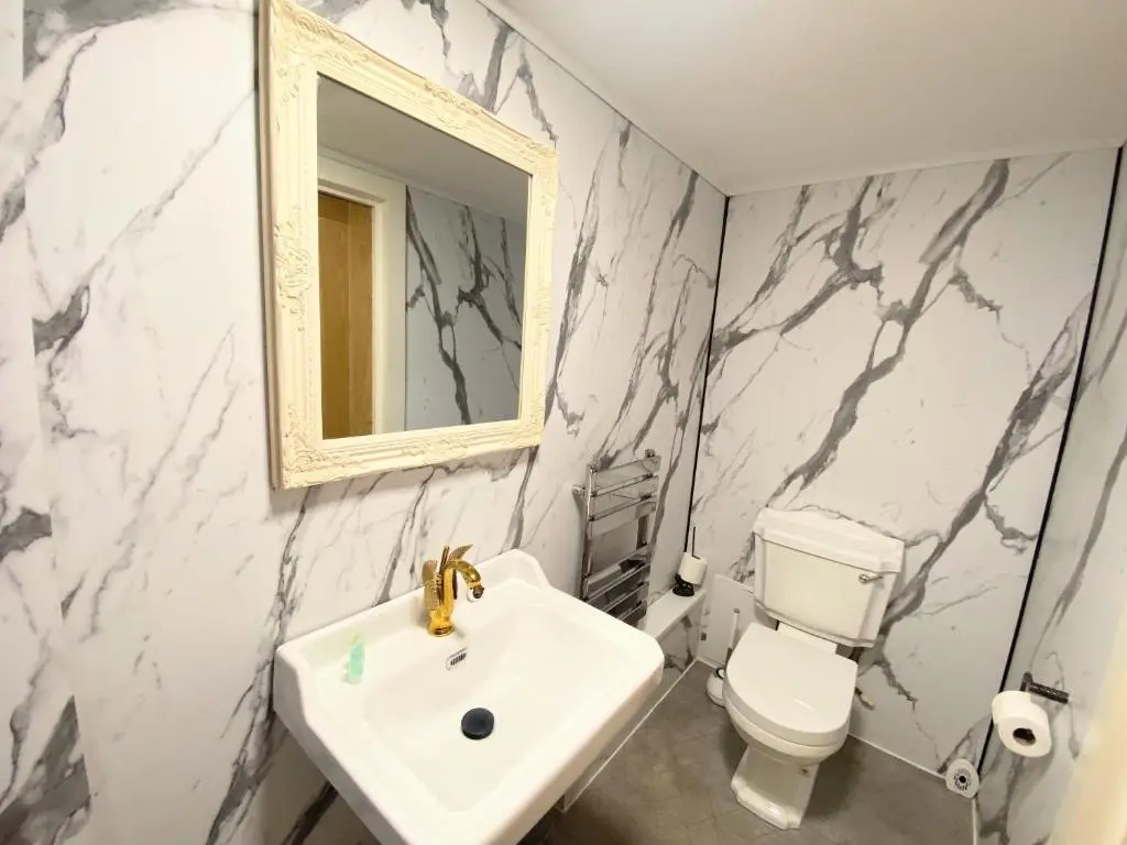 a bathroom with a sink and a toilet and a mirror at Kaoglen-GrandSuite-Hot Tub-Pitlochry-Dunkeld-Pet Friendly in Balnald