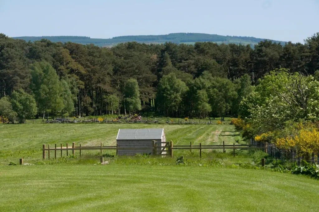 a barn in the middle of a field at Clovenstone Lodges in Inverurie