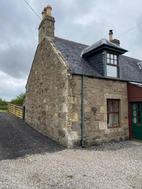 an old stone building with a green door at Quirky Highland Cottage with Stunning Views in Wester Fearn