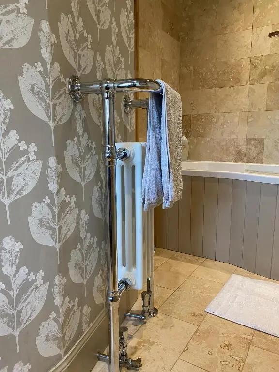 a shower in a bathroom with a towel on a wall at Quirky Highland Cottage with Stunning Views in Wester Fearn