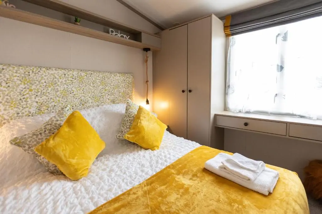 a bedroom with a bed with two towels on it at The Beach Hut, Burghead in Burghead