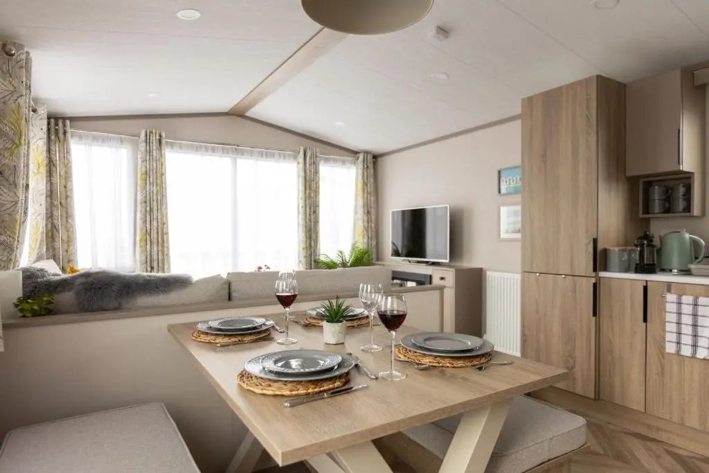 a living room with a table with glasses of wine at The Beach Hut, Burghead in Burghead