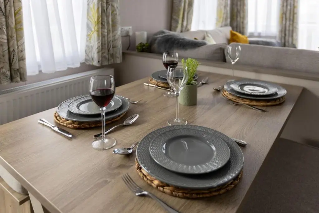 a table with plates and glasses of wine on it at The Beach Hut, Burghead in Burghead