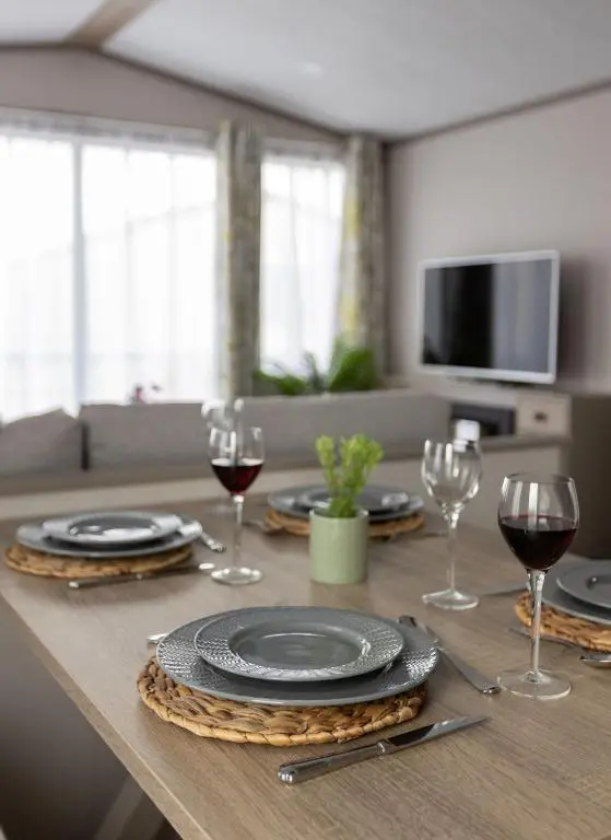 a table with plates and wine glasses on it at The Beach Hut, Burghead in Burghead