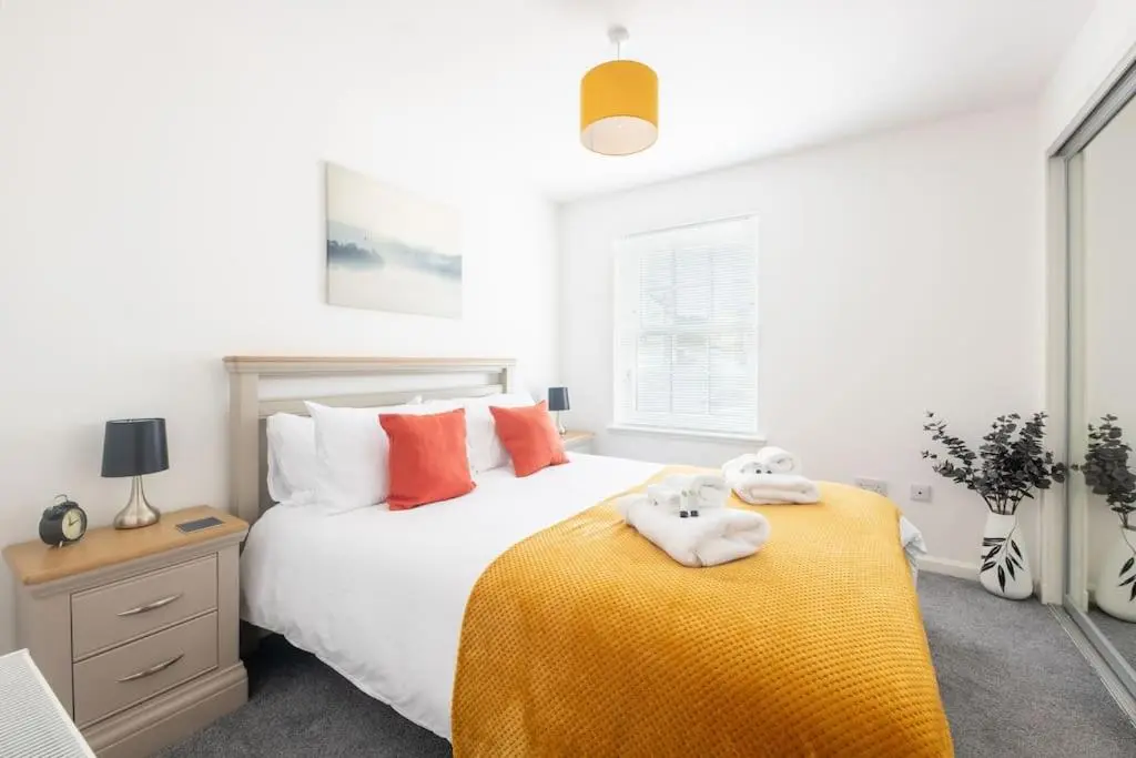 a bedroom with a bed with two towels on it at Modern Ground Floor Apartment in Tornagrain in Inverness