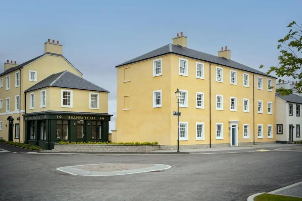 a large yellow building on the side of a street at Modern Ground Floor Apartment in Tornagrain in Inverness