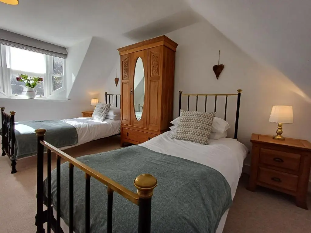 a bedroom with two beds and a dresser and a mirror at Creel Cottage Seatown Cullen with Garden in Cullen