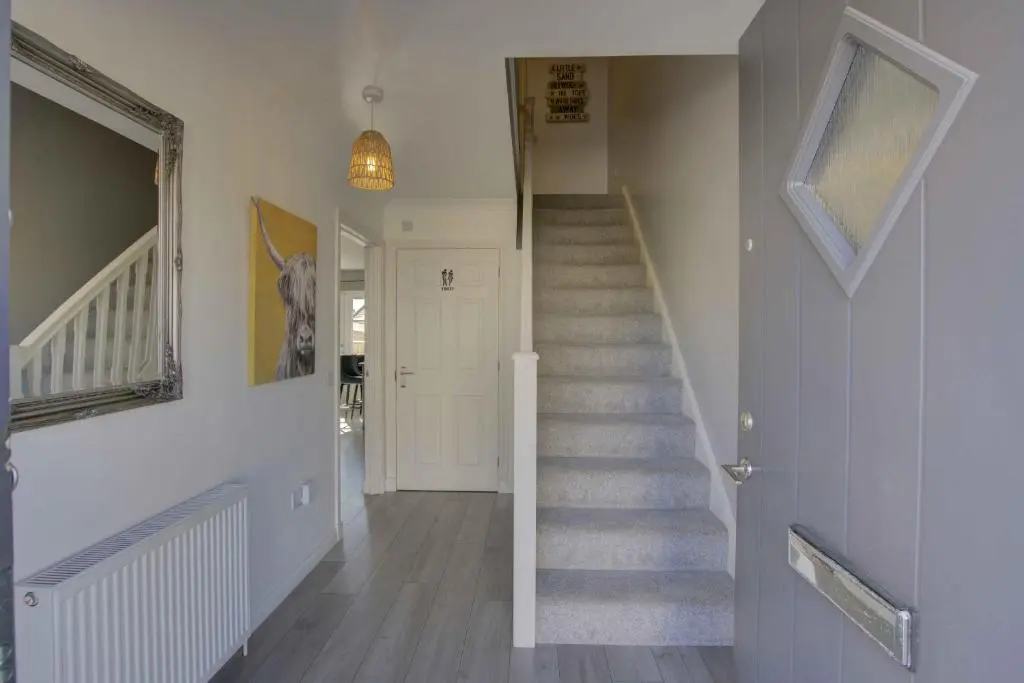 a hallway with a stairway with a stair case at 3 Mackay Road, Dornoch in Dornoch