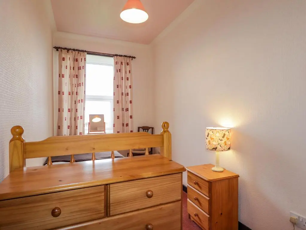 a bedroom with a wooden bed and a window at Star Croft in Wick