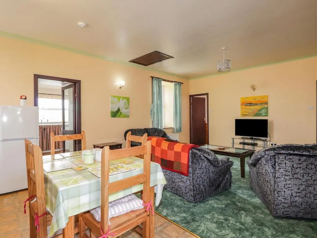 a living room with a table and chairs and a refrigerator at Star Croft in Wick
