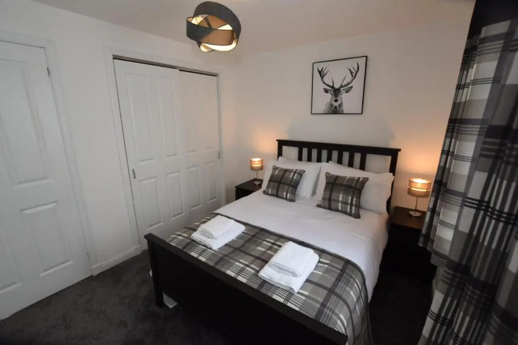 a bedroom with a bed with white sheets and pillows at Silver Key Apartments III in Inverness