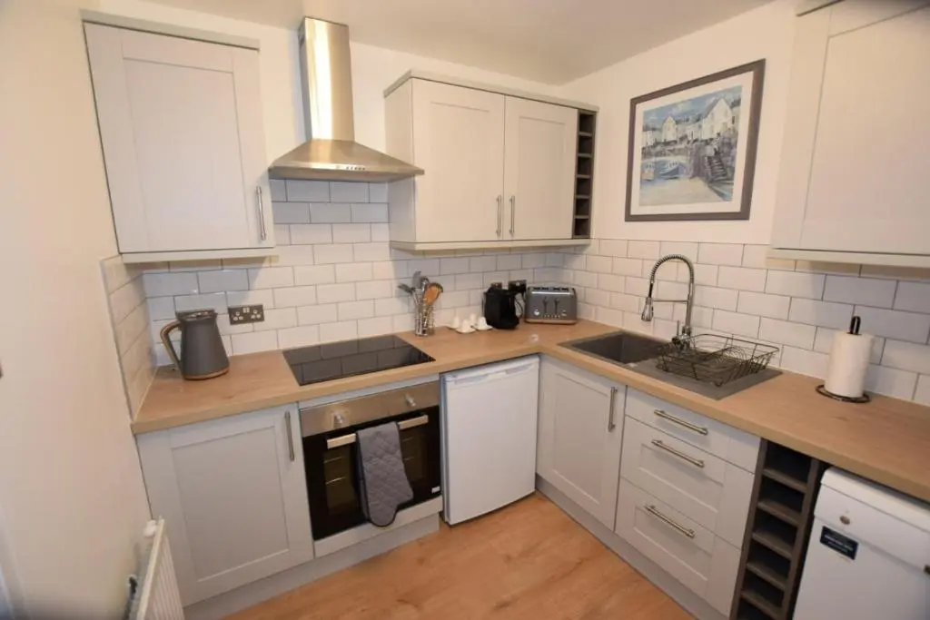 a kitchen with white cabinets and a sink at Silver Key Apartments III in Inverness