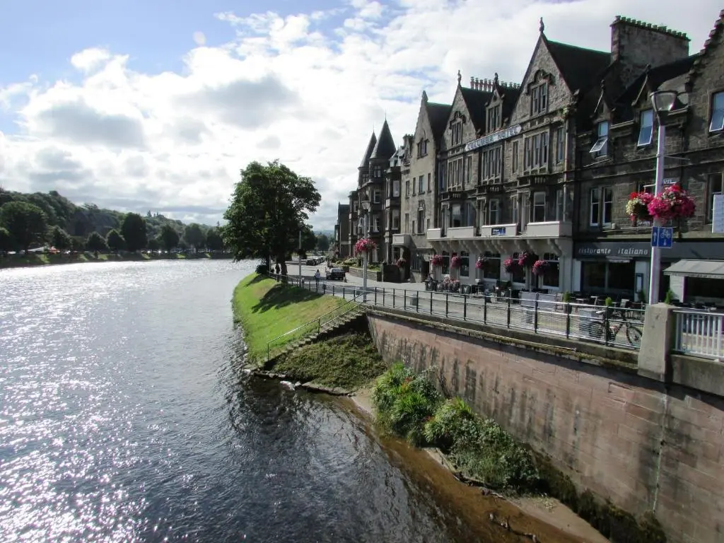 a river in a town with buildings next to it at Silver Key Apartments III in Inverness