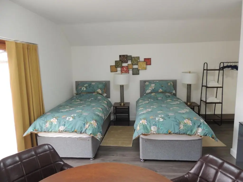 a bedroom with two beds and a table and chairs at Braeview Studio in Macduff