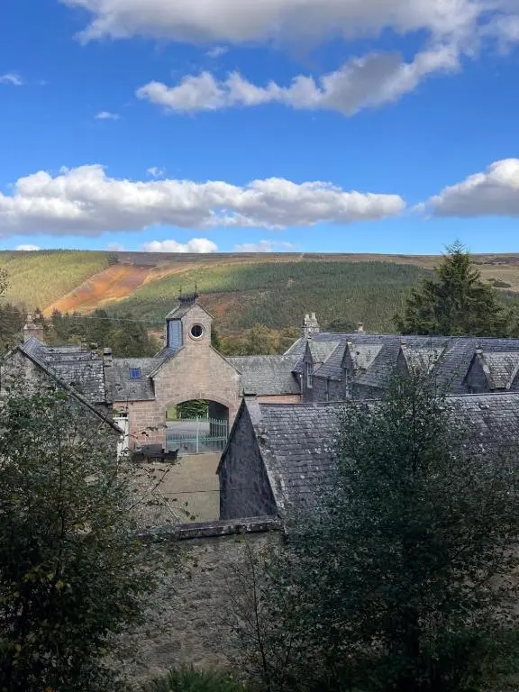 a group of roofs of houses with a field in the background at Brylach Steading in Aberlour