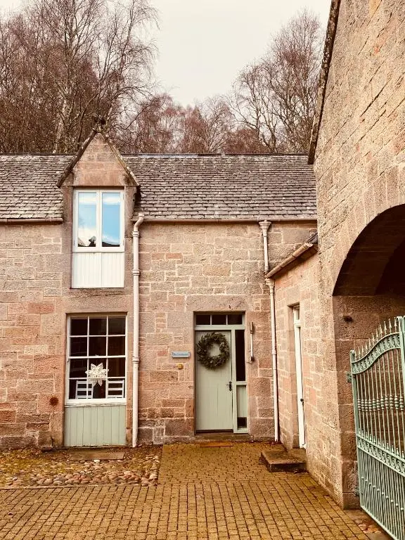 a brick building with a door and a window at Brylach Steading in Aberlour