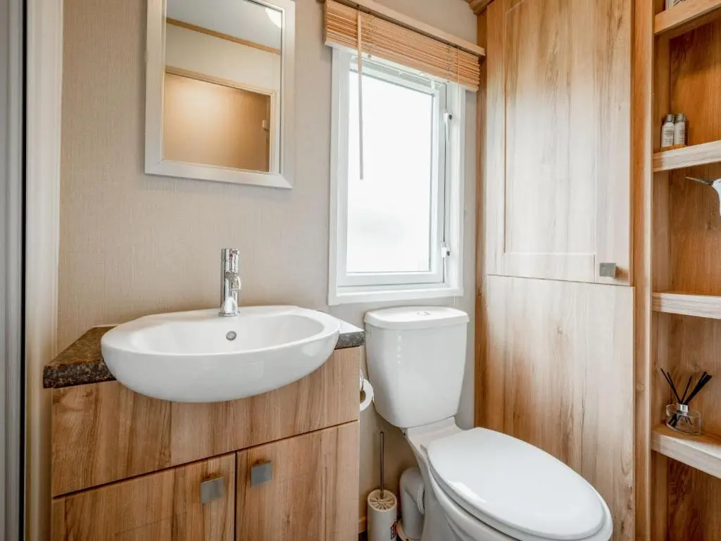 a bathroom with a white sink and a toilet at Holiday Home Golf View by Interhome in Nairn