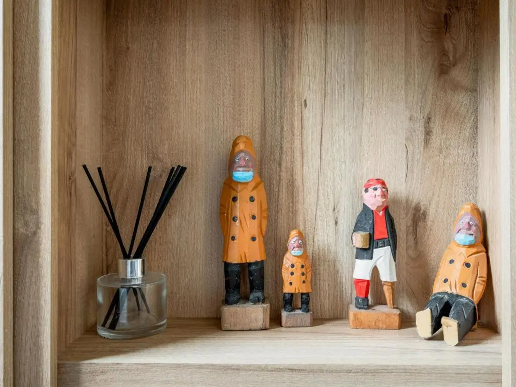 a shelf with three wooden figurines in a drawer at Holiday Home Golf View by Interhome in Nairn