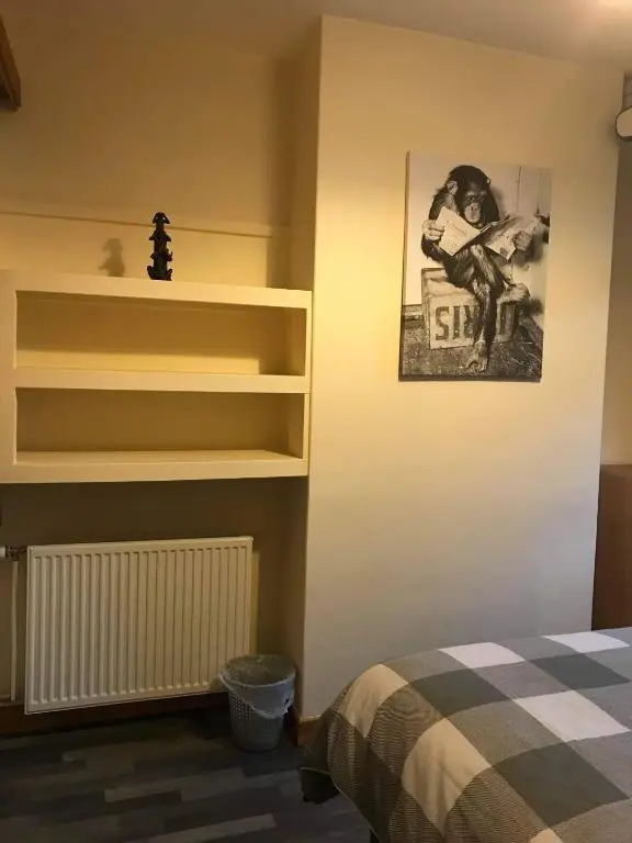a bedroom with a bed and shelves and a picture at No 5 Newly refurbished 4 bedroom house in Cononbridge