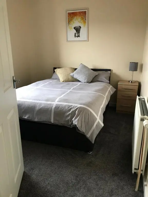 a bedroom with a bed and a picture on the wall at No 5 Newly refurbished 4 bedroom house in Cononbridge