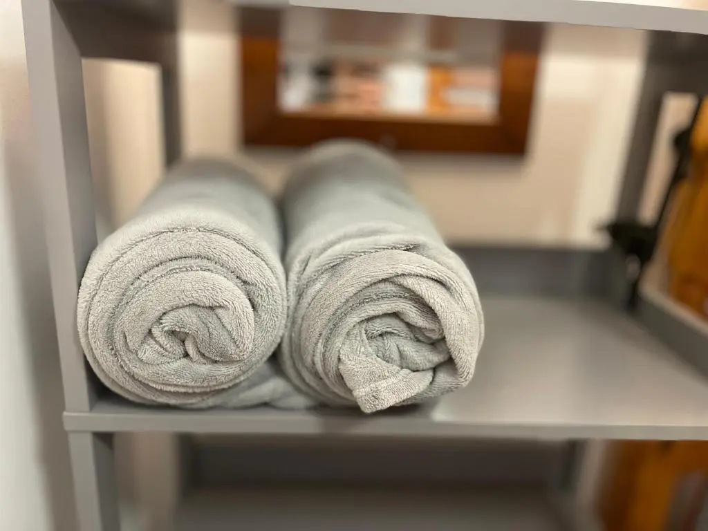 two rolls of towels sitting on a shelf at Stylish Garden Flat Near Loch Ness in Drumnadrochit