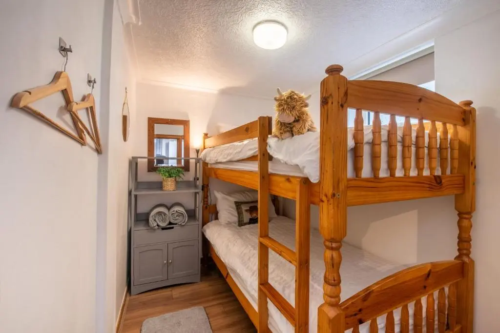 a bedroom with two bunk beds in a room at Stylish Garden Flat Near Loch Ness in Drumnadrochit