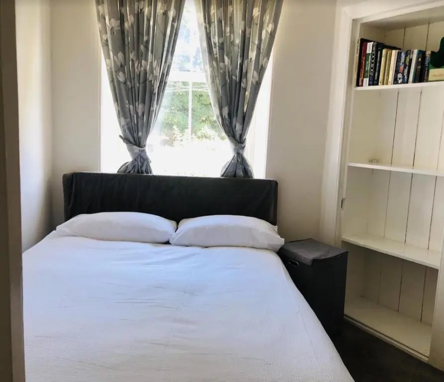 a bedroom with a bed with a window with curtains at The Castle Front Nest in Inverness