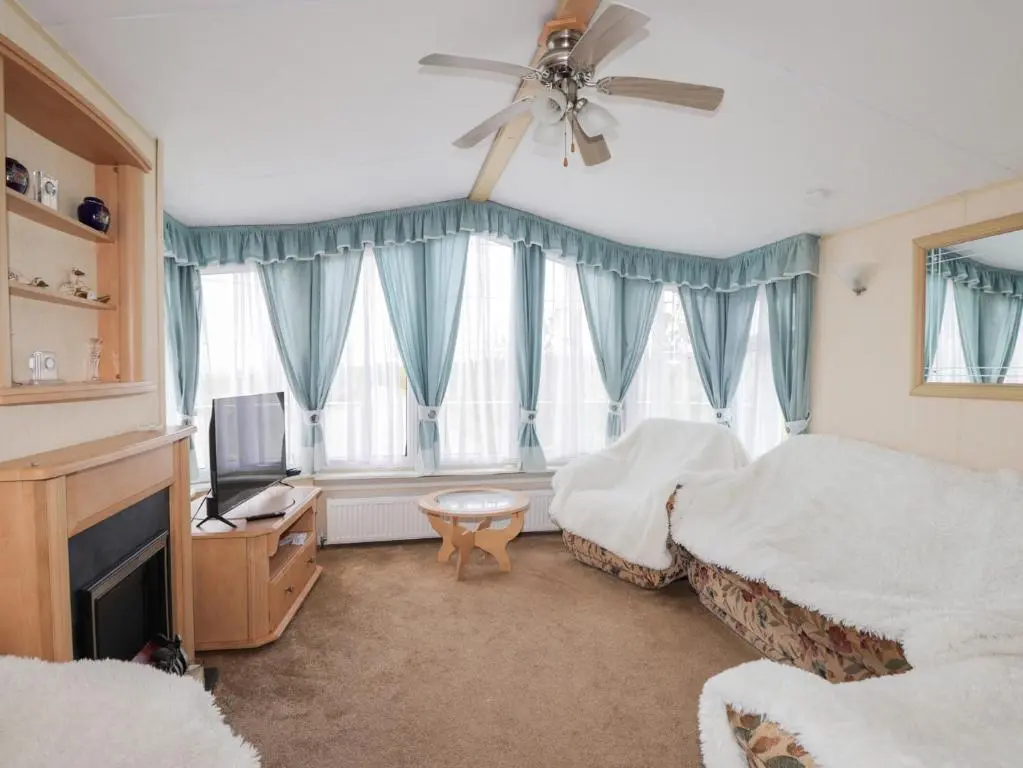 a bedroom with a bed and a ceiling fan at The Cabin in Lybster