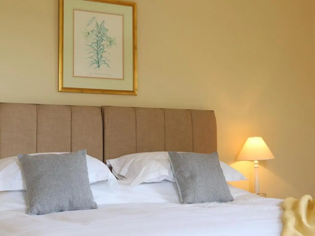 a bed with two pillows and a picture on the wall at Mains of Orton in Fochabers