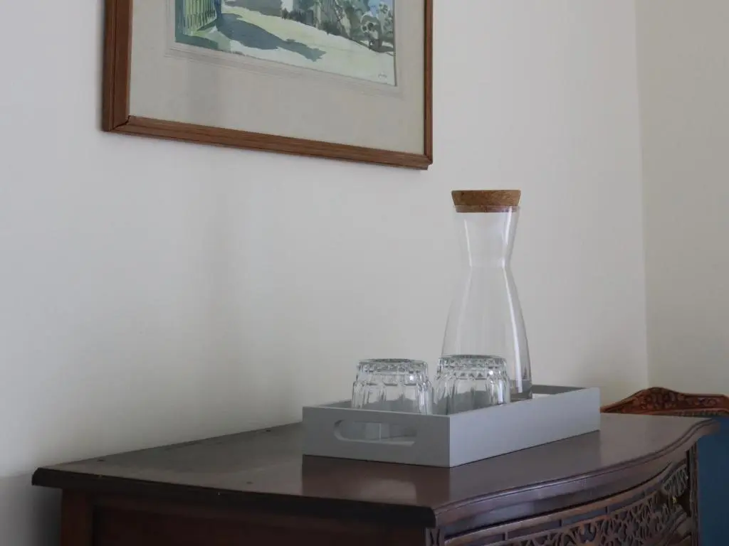 a vase sitting on top of a table with glasses at Mains of Orton in Fochabers