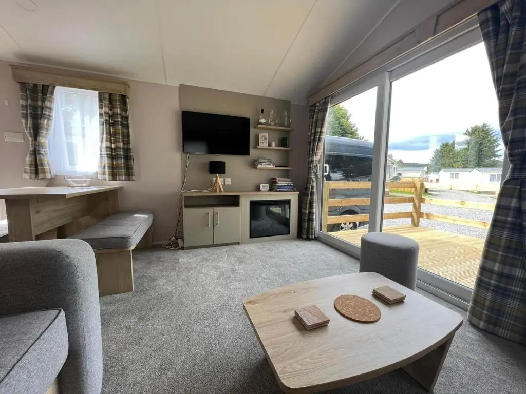 a living room with a couch and a table at The Wee Hoose in Boat of Garten