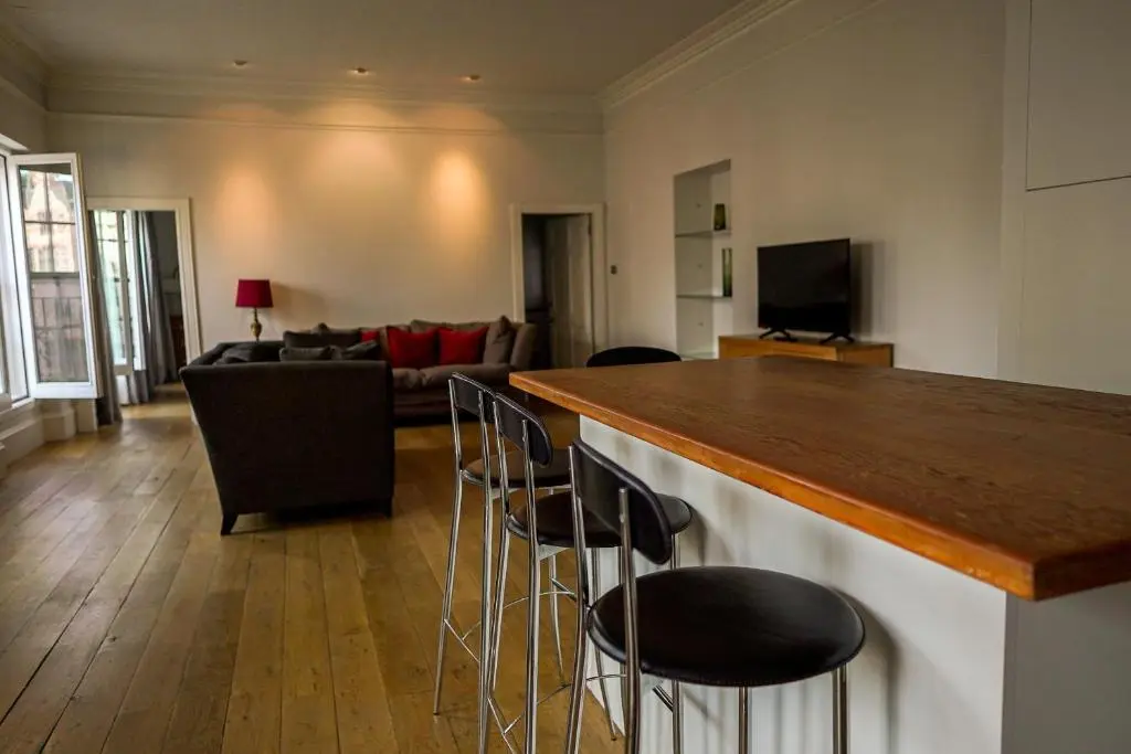 a kitchen and living room with a bar and chairs at Central 1-Bed Apartment in Inverness Sleeps 4 in Inverness