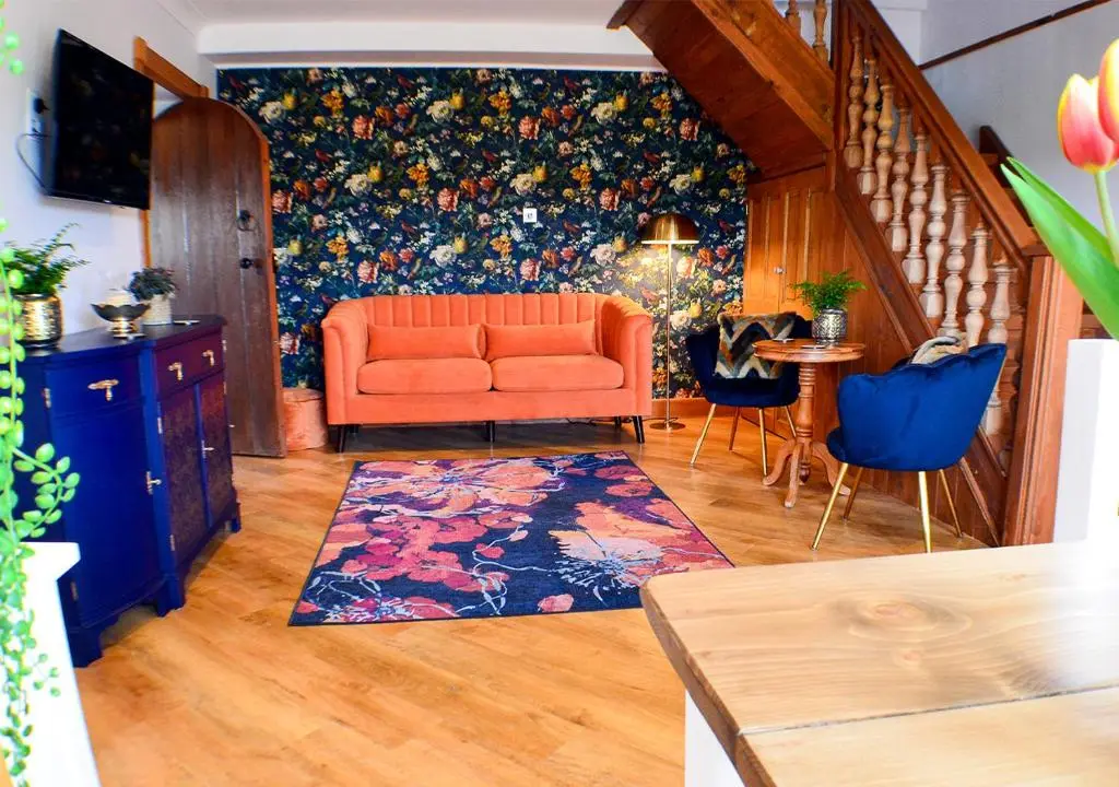 a living room with an orange couch and a table at The Tower, Moray Firth Holiday Home in Kinloss