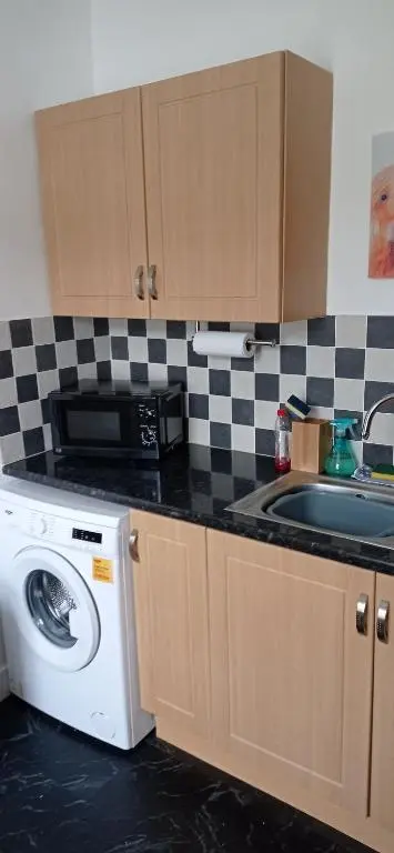 a kitchen with a washing machine and a sink at Isla Way Stays in Keith