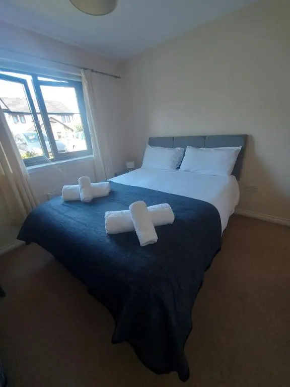 a bedroom with a large bed with two white towels on it at The Mews in Inverness