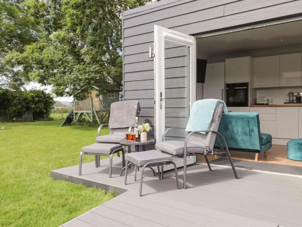 a patio with two chairs and a table and a kitchen at Moss of Bourach in Aberlour