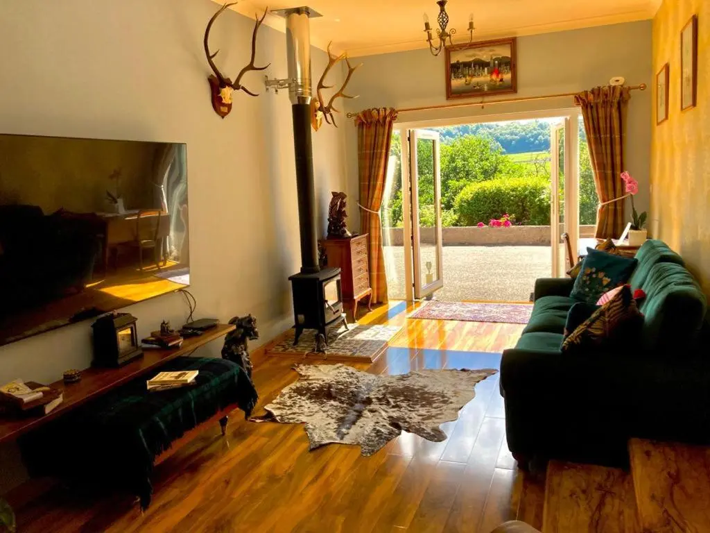a living room with two couches and a fireplace at The Guest suite at Daviot ,Inverness in Inverness