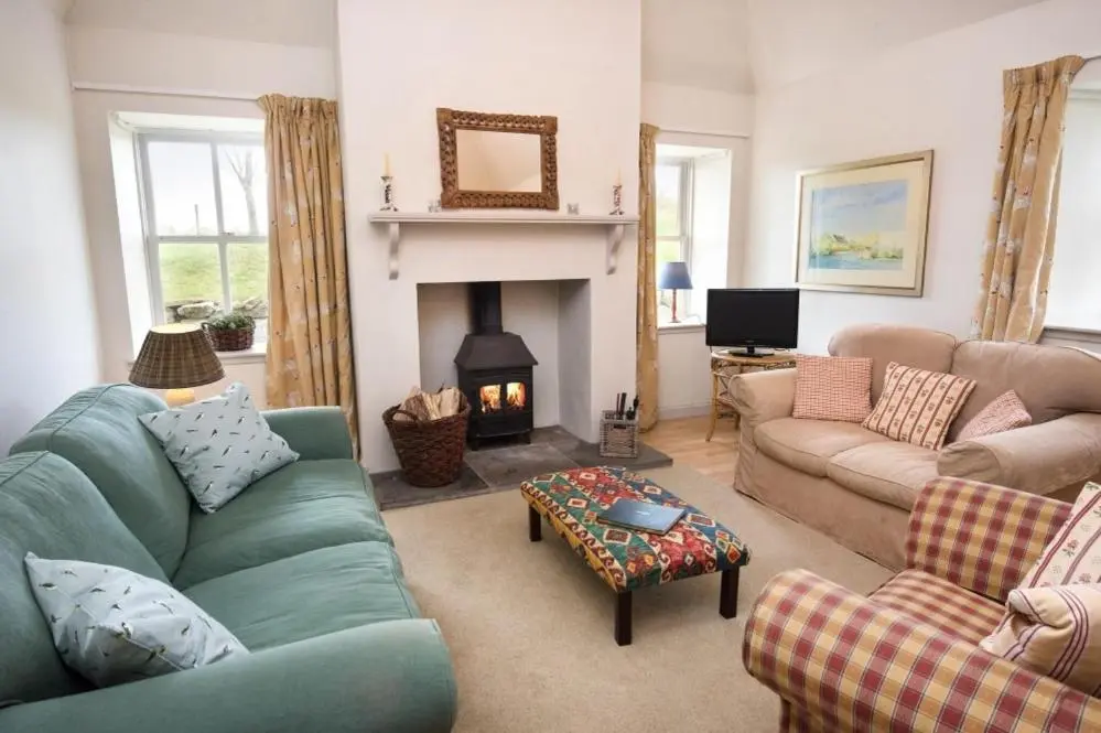 a living room with a couch and a fireplace at Gardener's Cottage in Elgin