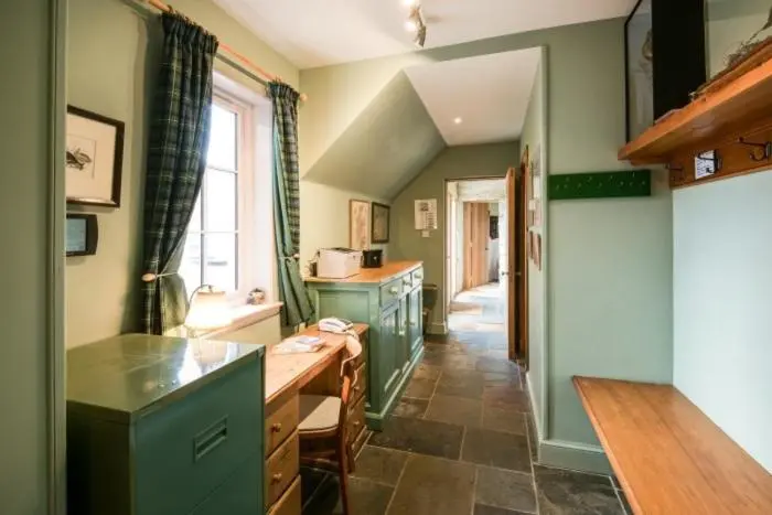 a kitchen with green cabinets and a table in it at Clashindeugle Farmhouse & Annex in Grantown on Spey