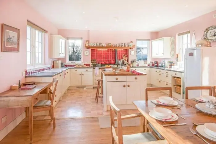 a kitchen with a table and chairs and a refrigerator at Clashindeugle Farmhouse & Annex in Grantown on Spey