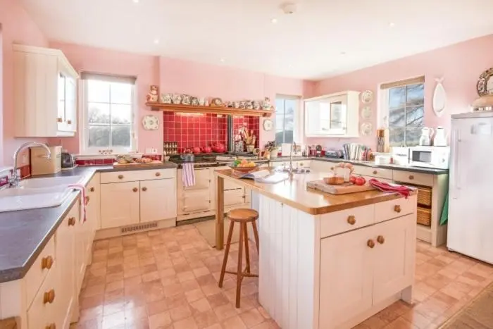 a large kitchen with white cabinets and a counter top at Clashindeugle Farmhouse & Annex in Grantown on Spey