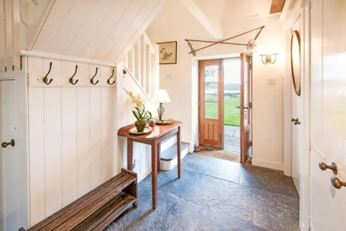 a hallway with a table and a door in a house at Clashindeugle Farmhouse & Annex in Grantown on Spey