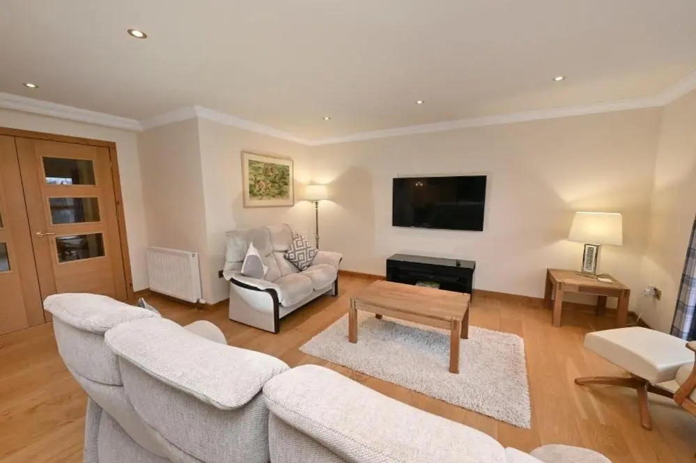 a living room with a couch and a table at Inverness City Apartment in Inverness