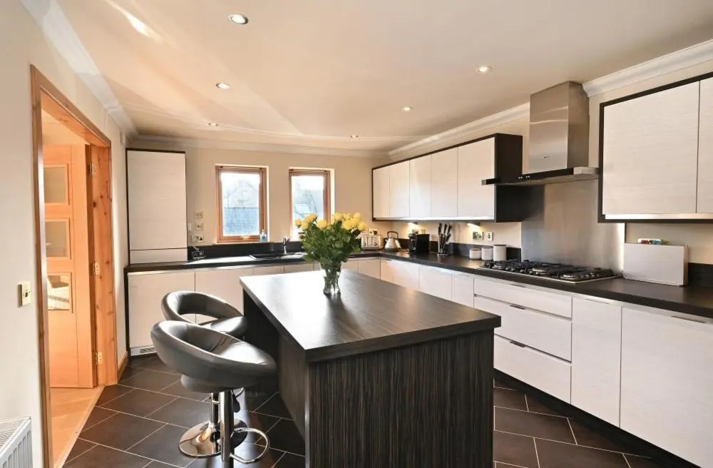 a kitchen with a island with a vase of flowers on it at Inverness City Apartment in Inverness